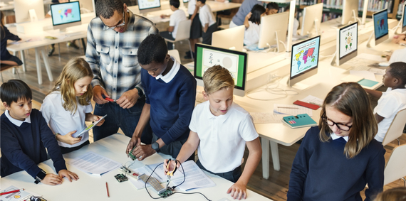 Instructor teaching children basic mechanical lessons in a library.